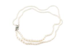 A cultured pearl necklace with gem set clasp, designed as two strands of graduated cultured