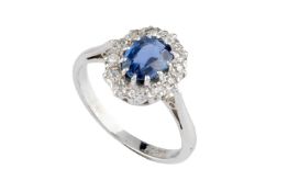 A sapphire and diamond cluster ring, the oval mixed-cut sapphire claw set within a single-cut