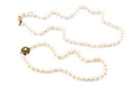 Two cultured pearl necklaces, each of single strand design, the first with a gem set and cultured