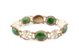 A nephrite panel bracelet, designed as a line of oval nephrite cabochons spaced by Eastern character