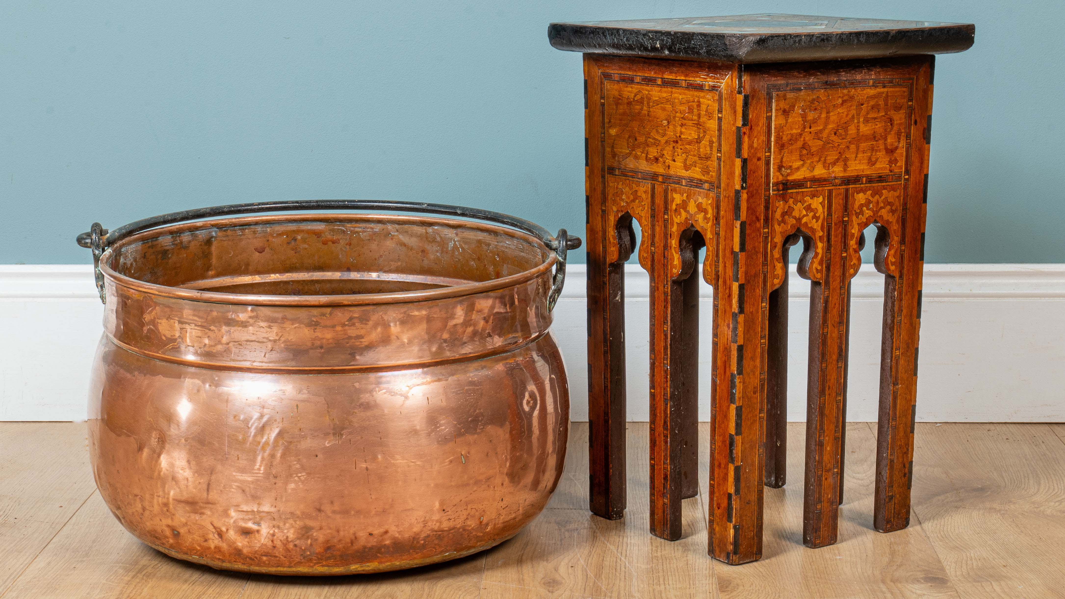 A small middle eastern table and a copper cauldron The cauldron with ...