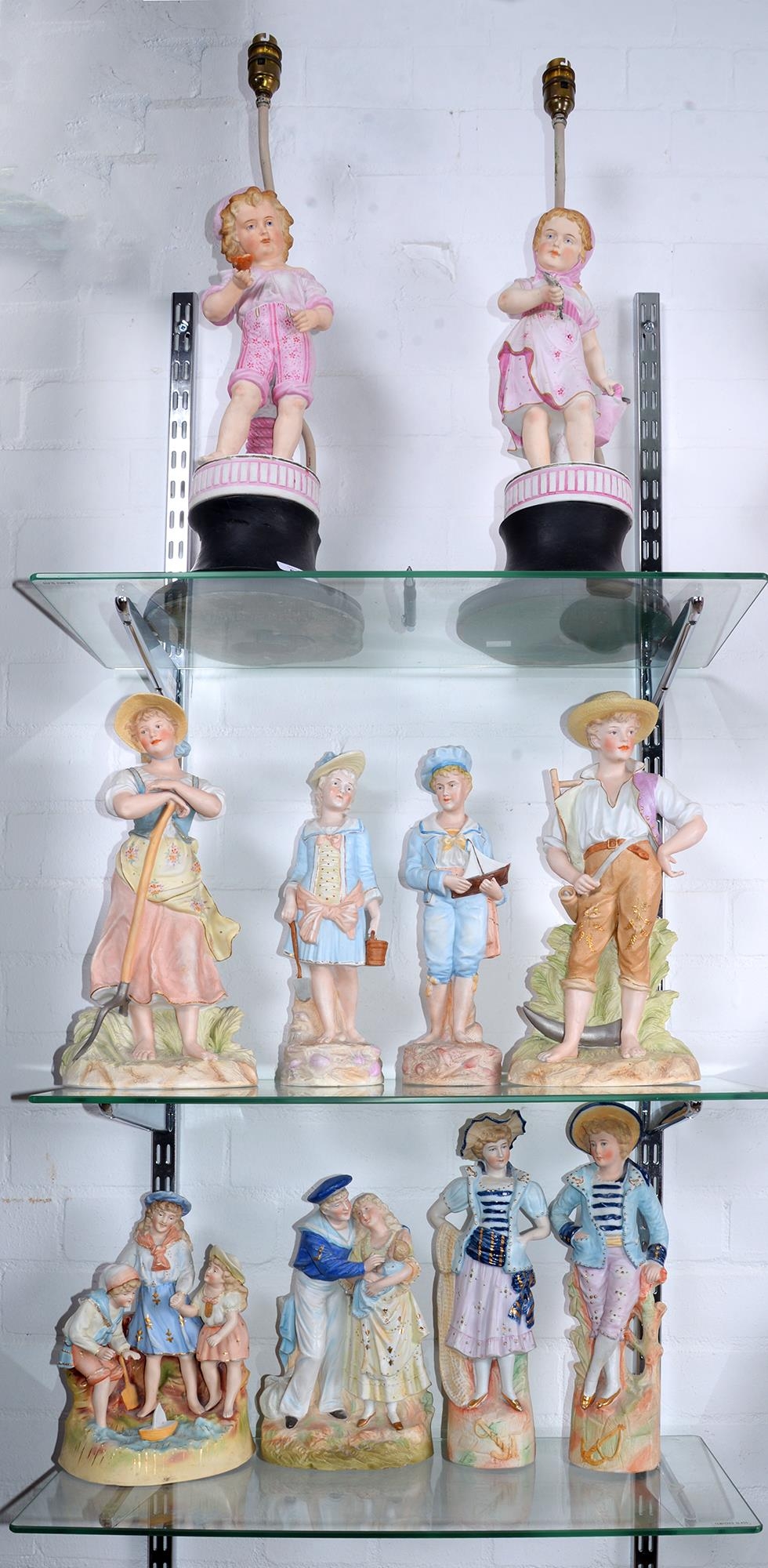 Miscellaneous painted bisque figures and groups, c1900, to include a group of a sailor and his