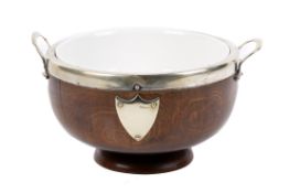 An EPNS mounted footed oak bowl with ceramic liner. Having two handles and a shield shaped plaque.