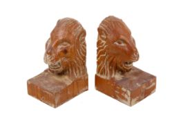 A pair of carved wooden lion head bookends.