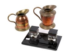 An Art Deco ink stand with two copper and brass jugs.