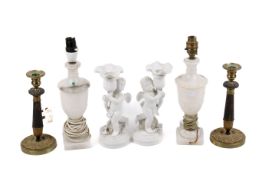 Two pairs of candlesticks and a pair of table lamps.