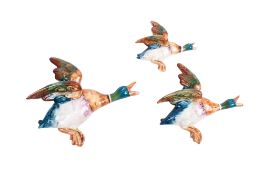 A set of three Beswick ceramic flying wall pocket ducks. Of graduated sizes, largest L22.