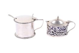 Two William Hutton & Sons Ltd silver condiment pots with spoons and blue glass liners.