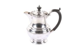 An early 20th century silver water pot. With serpentine rim over stepped waist and spread foot.