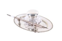 A silver lidded inkwell with a silver pen and silverplated dish.