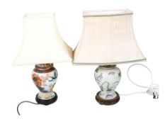 Two Chinese style ginger jar table lamps with shades. Having hardwood stands.