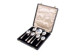 An Art Deco set of six silver dessert spoons and a serving spoon.