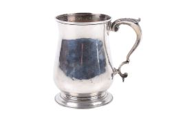 A white metal tankard. With scroll handle, raised on a stepped base.