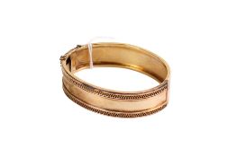 A 9ct gold (tested) yellow metal hinged bangle.