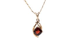 A 9ct gold (tested) single stone garnet pendant and attendant chain.