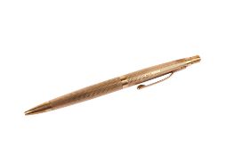A 9ct gold cased ballpoint pen. With engine turned decoration, hallmarked, gross weight 19.3g.