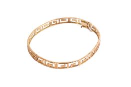 A 14ct gold (tested) hinged bangle with Greek key motif.