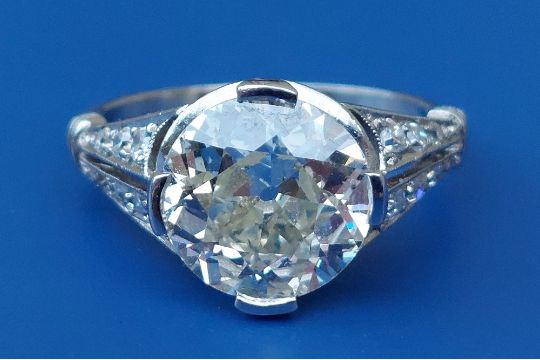 An old cut diamond ring, the claw set stone weighing approximately 3 carats, millegrain set diamonds - Image 1 of 7