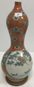 A circa 1900 Japanese Meji period gourd shaped vase decorated with two panels depicting birds