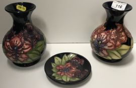 Two circa 1996 Moorcroft dark blue ground floral decorated baluster shaped vases with flared rims
