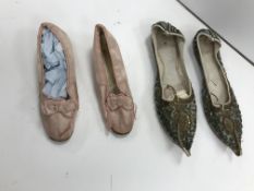 A pair of pink satin child's shoes with