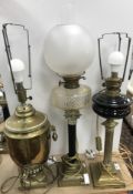 A collection of three brass table lamps including a brass and black painted Corinthian column table