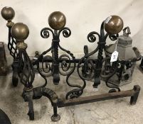 A pair of wrought iron fire dogs with br