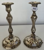 A pair of white metal candle sticks of b