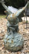 A cast crying angel on a ball, 31cm high