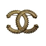 A Chanel ‘CC’ gilt metal pin brooch, stamped ‘Chanel A18’ in oval lozenge to reverse, 5cm wide.