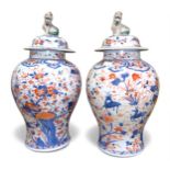 a pair of Chinese porcelain vases and covers, of inverted baluster form with temple dog finials