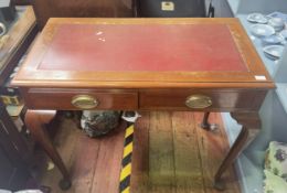 A small mahogany desk, with inset red leather scribe, two frieze drawers with oval handles decorated