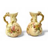A pair of Royal Worcester blush ivory quatrelobe jugs, dated 1906, decorated with hand-painted