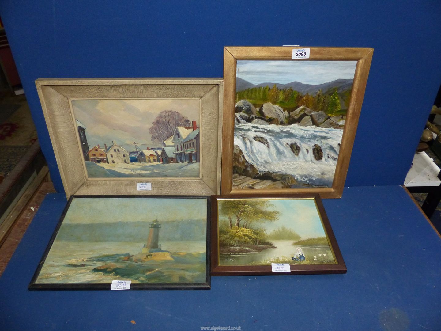 Four Oil paintings to include: a lighthouse on rocks, written verso ...