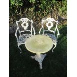 A pair of white garden chairs together with a marble top table and stand