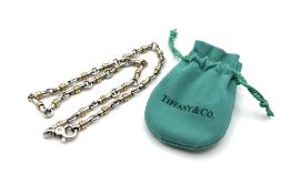 Tiffany & Co, a silver and 18ct gold bar link tube necklace, with cloth pouch.