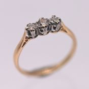 A diamond three stone ring, set in 18ct yellow gold, size N, approx 2.1g.
