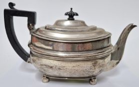A George III silver teapot, hallmarked London 1810, on bun feet with ebonised handle and finial,