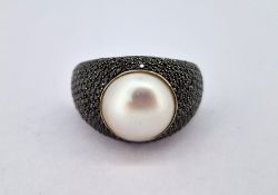 An 18ct white gold and pearl dress ring set with black sapphires (?), size L/M, approx 7.6g.