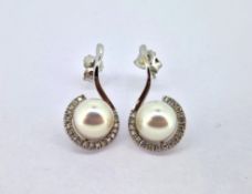 A pair of diamond and pearl swirl earrings, set in 18ct white gold, diameter of pearl approx 9mm.
