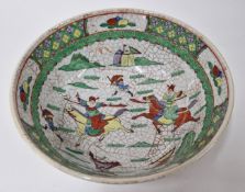 A Chinese bowl, decorated with soldiers on horseback in green, with painted cracking throughout,