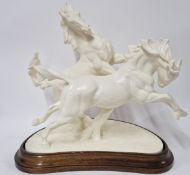 A Royal Worcester group, 'Galloping Horses', modelled by Doris Lindner, on a wooden plinth,