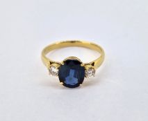A diamond and sapphire three stone ring, possibly 18ct yellow gold (hallmarked rubbed), size L/M,