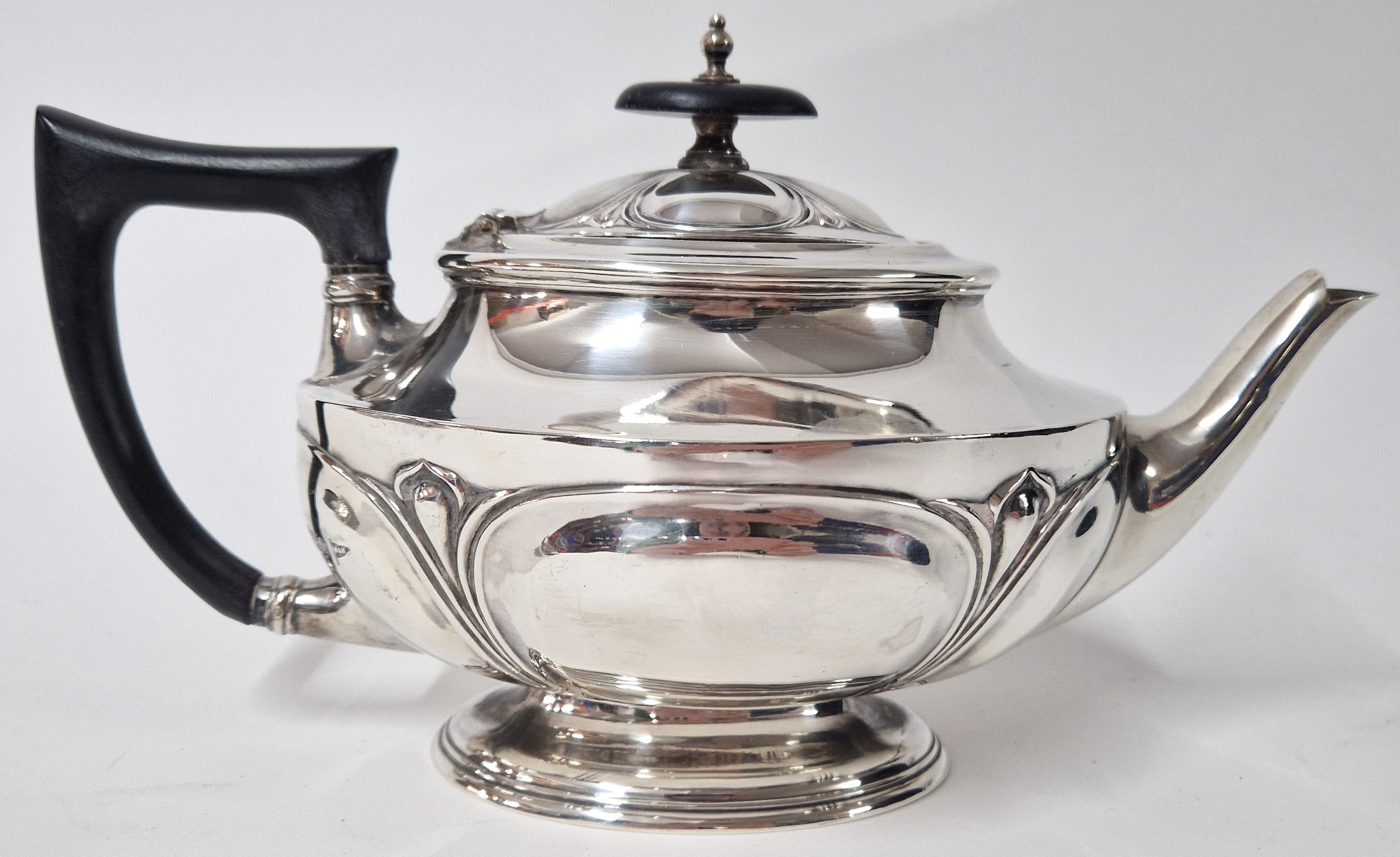A silver teapot, hallmarked Sheffield 1912, with ebonised wooden handle and finial, total weight