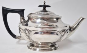 A silver teapot, hallmarked Sheffield 1912, with ebonised wooden handle and finial, total weight