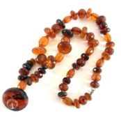 An amber necklace set with chunky beads, approx 117.2g, together with two seed pearl brooches (one