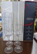 Three boxed bottles of Champagne, together with four glass champagne flutes.