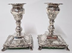 A pair of Edward VII silver candlesticks, hallmarked Sheffield 1904, with elaborate embossed