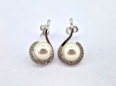 A pair of diamond and pearl swirl earrings, set in 18ct white gold, diameter of pearl approx 9mm.