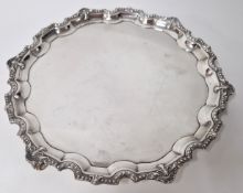 A silver salver or tray, hallmarked Sheffield 1967, on three scroll feet and embossed rim by